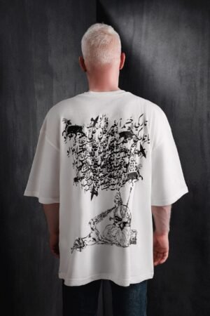 Back view of a model wearing the Makouk Studios "Habibi" white t-shirt featuring Arabic calligraphy and an illustrated shepherd with goats, designed by Mohamad Ali Makouk.Global Streetwear political commentary Rebellious Energy Misfits Limited Edition Streetwear