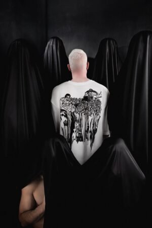 Male model wearing white Makouk Studios t-shirt with black illustration of men marching in conformity, from Macho Meltdown Collection by Mohamad Ali Makouk.