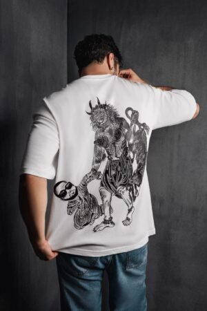 Male model wearing Makouk Studios oversized white t-shirt with black hand-drawn demon and baby illustration, part of the Moral Decay collection.