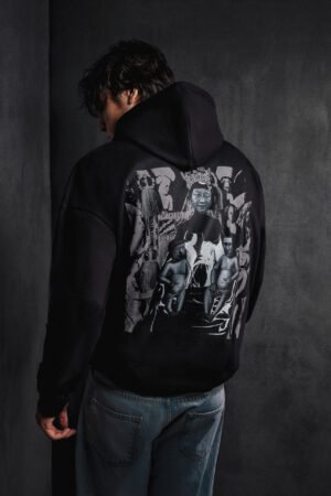 Male model wearing Makouk Studios black hoodie with surreal collage featuring political figures and pop culture icons, part of the Political Nursery Collection.