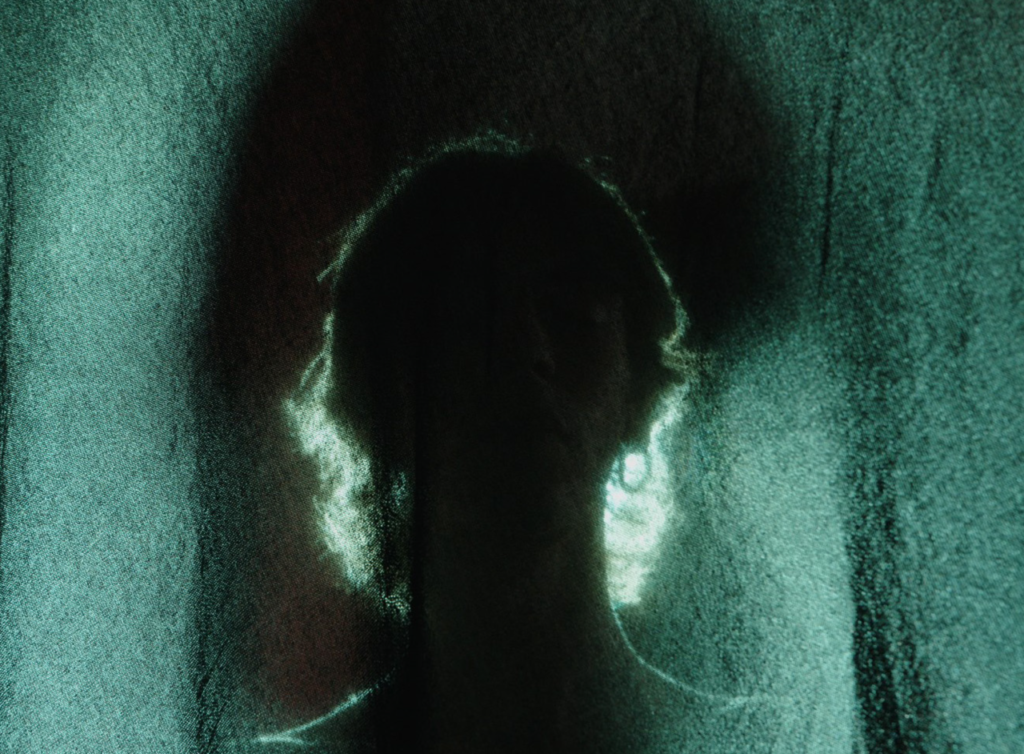 Still from “Blurry Line” fashion film by Makouk Studios. Shadowy silhouette behind fabric, filmed in Italy.